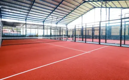 Terracotta padel courts under a high roof